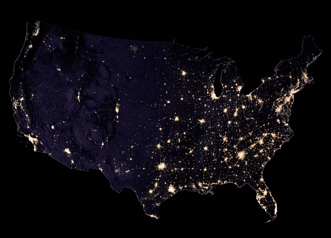 Satellite view of the United States at night, illuminated by city lights from coast to coast