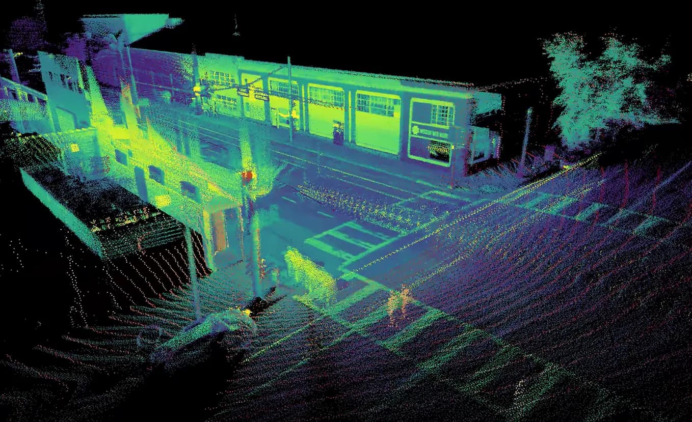 Colored LIDAR-style point cloud of an urban scene: buildings, a platform, and surrounding ground rendered as a dense field of magenta, yellow, green, and cyan points. A spatial metaphor for Atrium's observable agent workspace.